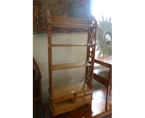 A rustic pine hanging wall shelf with three shelves and four drawers.