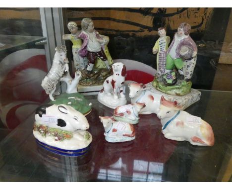 A mixed group of Staffordshire ceramic items to include a rabbit, spaniel, mountain goat, herd of four cows, and two figures 