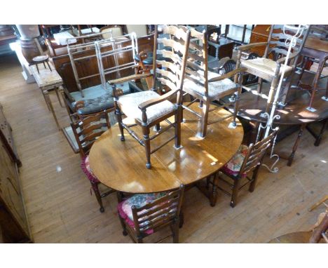 A good quality 18th Century style oval oak drop leaf dining table with six conforming ladder back chairs including two carver