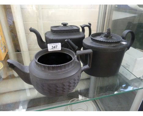 Three late 18th/19th Century basalt ware teapots the first example of plain oval form having a widow finial above a single ba