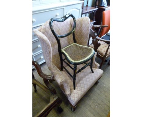 An early 20th Century wing back armchair, together with a Victorian mother of pearl inlaid cane seated bedroom chair.