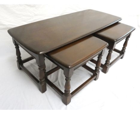 ERCOL OAK NEST OF TABLES
comprising an oblong table and two smaller tables below, standing on turned supports united by a str