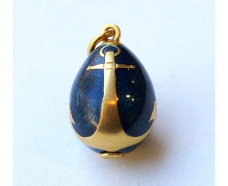 DECORATIVE RUSSIAN ENAMELLED EGG CHARM
with applied gold anchors to the blue enamel body, the ring marked 'AU', with stylised