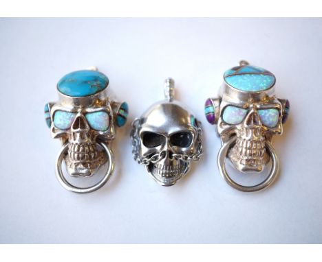 TWO SILVER SKULL PENDANTS
set with turquoise and opal, one marked Sterling to the circular ring through the skull's mouth; to