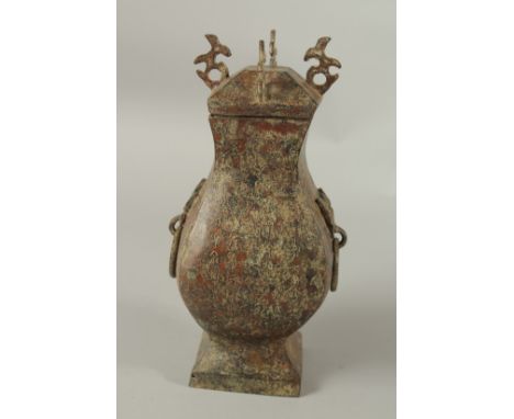 AN ARCHAIC BRONZE TWO-HANDLED VASE AND COVER with ring handles. 28cms high.