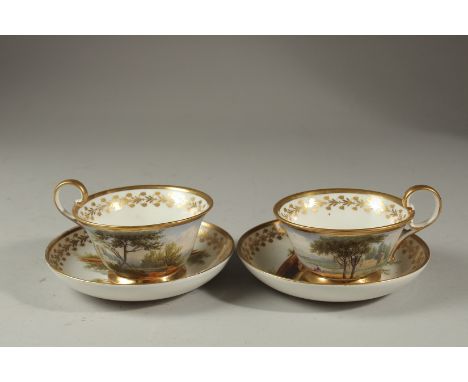 A PAIR OF ENGLISH PORCELAIN CUPS AND SAUCERS painted with classical lake scenes.