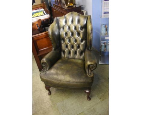 A green leather Chesterfield button back armchair