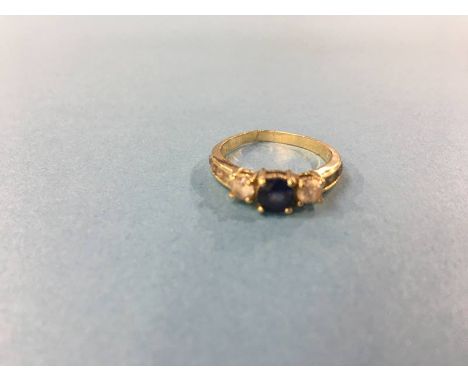 A gold coloured dress ring, mounted with blue and white sapphire