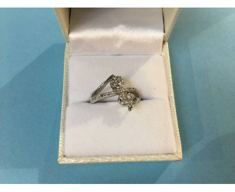 A white metal ring (marks obscured), set with diamond clusters, size 'N', 3.1g 