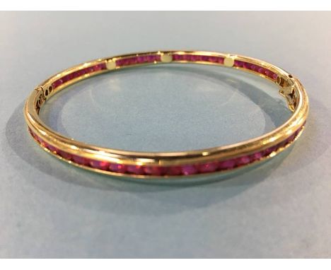 An Indian ruby mounted bangle, stamped '14', 13.4g
