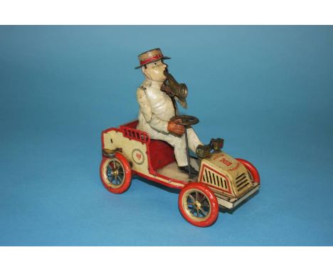 A 1920s Lehmann tinplate clockwork tin plate 490 'Tut Tut' automobile, the cream car with red trim, the driver wearing a whit