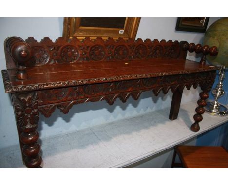 An oak carved bench, with carved frieze and bobbin turned legs, 120cm length