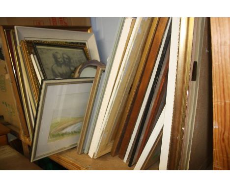 A shelf of framed paintings etc.