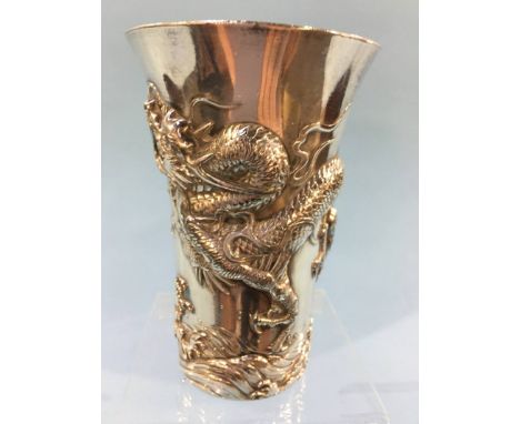 A silver plated Chinese beaker, decorated with embossed dragons