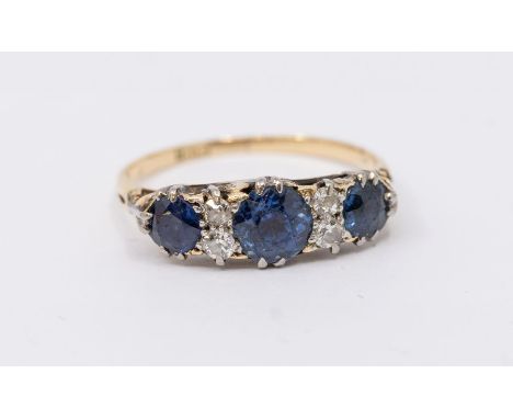 An early 20th century diamond and sapphire set ladies 18ct gold ring, comprising three graduated  round cut sapphires, the la