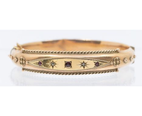 A Victorian ruby and diamond set 9ct gold bangle, star set, applied canetille decoration, rope edge border, some damage and d