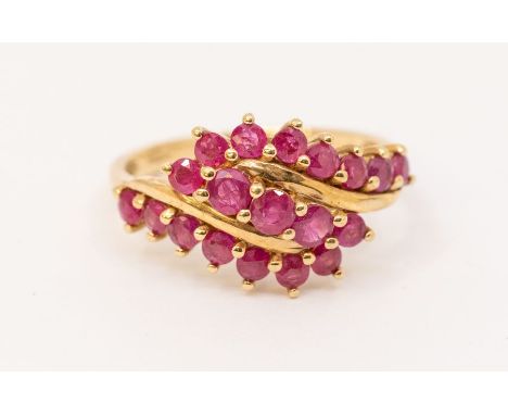 A ruby and 9ct gold cluster ring, comprising three claw set rows of round cut ruby decoration, width approx 12mm, size R, tot