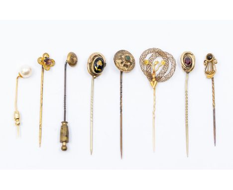 A collection of five 19th century yellow metal stick pins, including one in the form of a lyre; a memorial stick pin, set wit