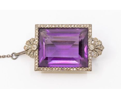 An Edwardian amethyst and diamond white metal brooch, rectangular step cut amethyst to the centre within a fine border of ros