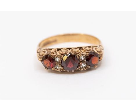 A 9ct rose gold, garnet and white stone ring, scroll decoration to shank, size P, total gross weight approx 3.4gmsFurther det