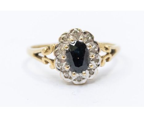 A sapphire and diamond 9ct gold ring, oval sapphire within an illusion set border of diamonds, size R1/2, total gross weight 