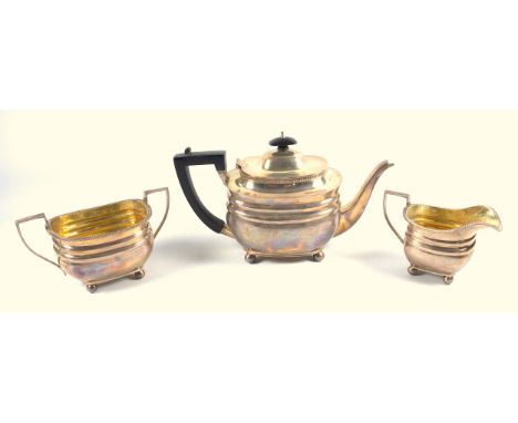 George V silver 3 piece tea set comprising a rounded rectangular teapot with moulded bands and gadrooned rim, on 4 ball feet,