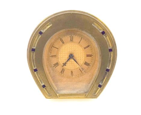 An unusual easel timepiece in the form of a horse shoe , with gilt engine turned dial with roman numerals, H. 7 cm 