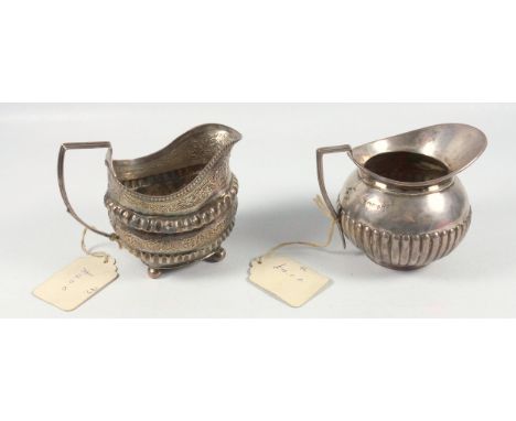 George III silver rounded rectangular milk jug with embossed fluted and chased floral bands, on 4 ball feet, London 1815, and