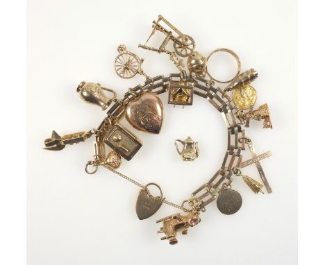 9ct. gold gate-link charm bracelet with 17 9ct. charms including a safe with opening door enclosing a vessel, windmill, corks