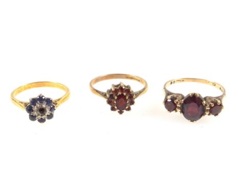 9ct. gold ring with an oval cut garnet flanked by 2 smaller circular garnets, size K½, another 9ct. garnet ring, gross 4.2grs