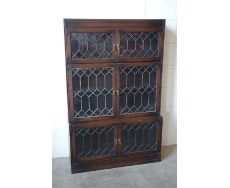 A pair of 1930?s oak sectional bookcases with three pairs of lead glazed panelled doors, H. 137.5 cm, W. 89cm, one bears Army