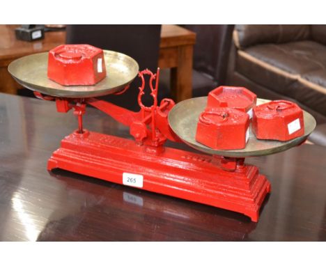 A set of French cast iron weighing scales, painted red with one 2kg weight and three 1kg weights.