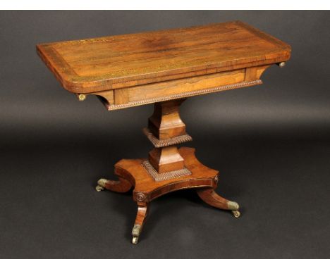 A Regency rosewood and brass marquetry rounded rectangular card table, folding top inlaid with a broad band of roundels and l