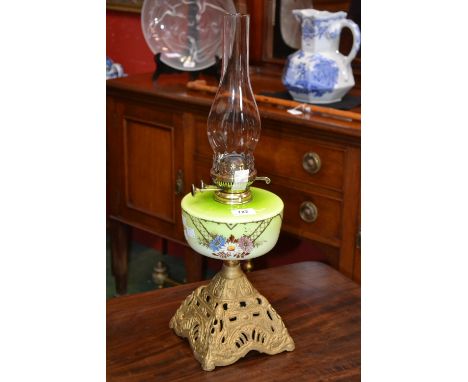 A Victorian oil lamp, cast iron base, enamelled opaque glass reservoir, Wright and Butler twin burner, 58cm high 