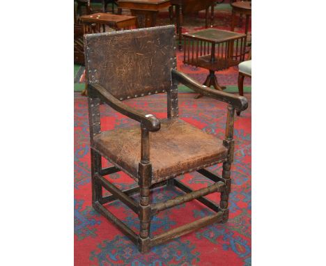 An oak open arm chair, leather padded back and seat, bobbin turned stretchers and supports, circa 1800