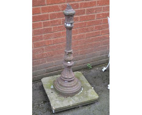 A cast iron ornamental lamp post, concrete base 