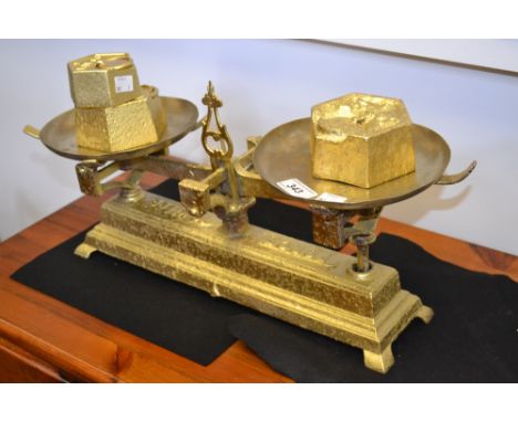 A set of French farmhouse cast iron weighing scales painted gold with two 2kg weights and one 1kg weight