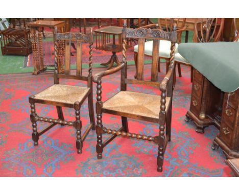A set of six Jacobean Revival oak dining chairs, comprising four side chairs and a pair of carvers, bobbin turned, rush seats