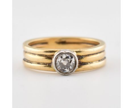 An 18ct gold and diamond solitaire ring.&nbsp; The ring set with an old cut diamond&nbsp; in a bezel setting to a ribbed trip