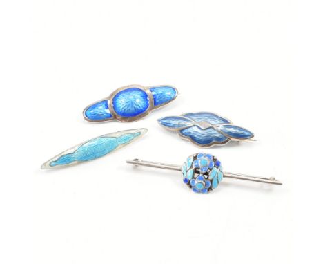 Four early 20th Century silver and enamel brooch pins. All being decorated with blue enamel, one having floral Arts and Craft