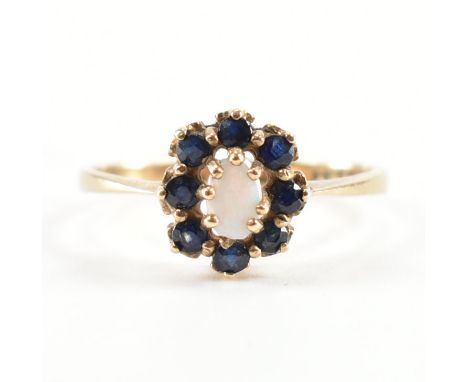 A hallmarked 9ct gold sapphire and opal halo ring. The ring being set with an oval opal cabochon with a halo of round cut sap