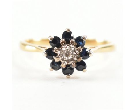 A vintage 18ct gold sapphire and diamond cluster ring. The ring being set with a central round brilliant cut diamond with a h