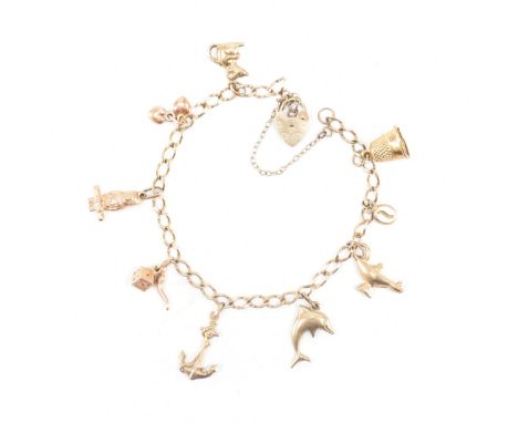 A hallmarked 9ct yellow gold heart padlock charm bracelet. The bracelet chain comprised of delicate curb links united by a he