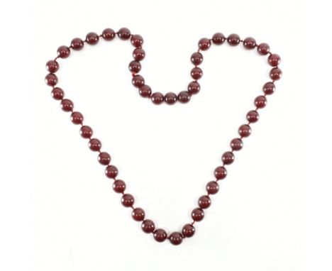 A vintage cherry bakelite beaded necklace. The necklace comprised of spherical deep red early plastic bakelite beads spaced b