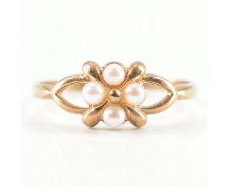 A hallmarked 9ct yellow gold &amp; pearl ring. The ring having four round white pearls set to a flower design head split &amp