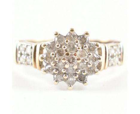 A 9ct gold and diamond cluster ring. The ring set with a central diamond cluster having diamond set shoulders to plain shank.