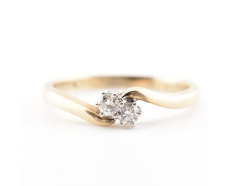 A hallmarked 18ct gold and diamond crossover ring. The ring set with two round brilliant cut diamonds in a crossover setting.