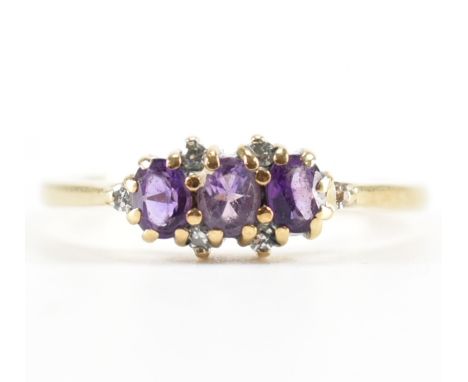 A hallmarked 9ct gold amethyst and diamond ring. The ring being set with three oval cut amethysts with round cut diamond acce