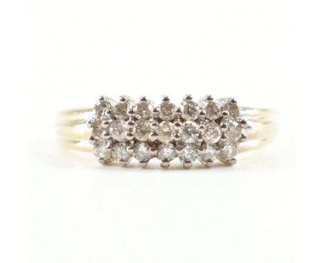 A 9ct yellow gold &amp; diamond cluster ring. The ring having three rows of round cut diamonds to gadrooned shoulders &amp; t