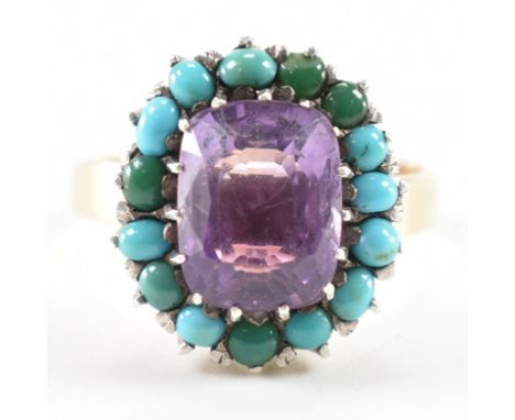 A gold amethyst and turquoise cluster ring. The ring set with a mixed cut amethyst framed by turquoise cabochons to plain gol